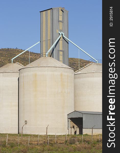 Grain silos holding wheat next to a hill. Grain silos holding wheat next to a hill