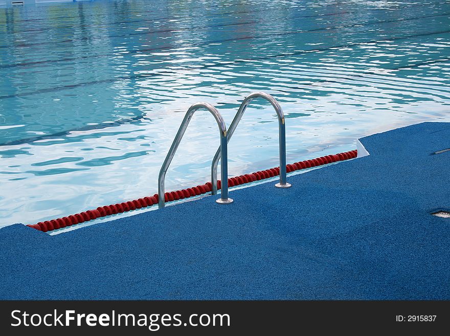 Metal chromeplated ladder in open pool. Metal chromeplated ladder in open pool