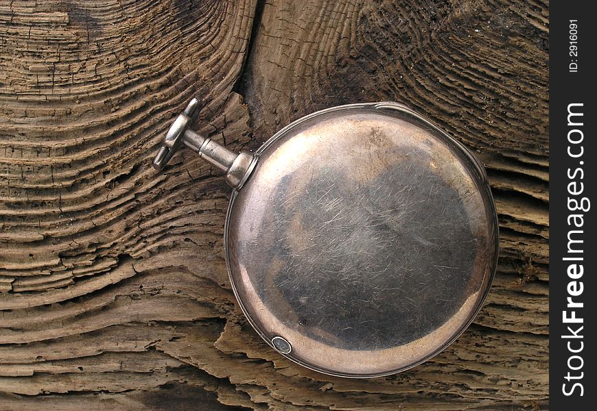 Silver pocket watch on driftwood