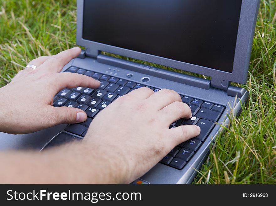 Hands and laptop on the herb