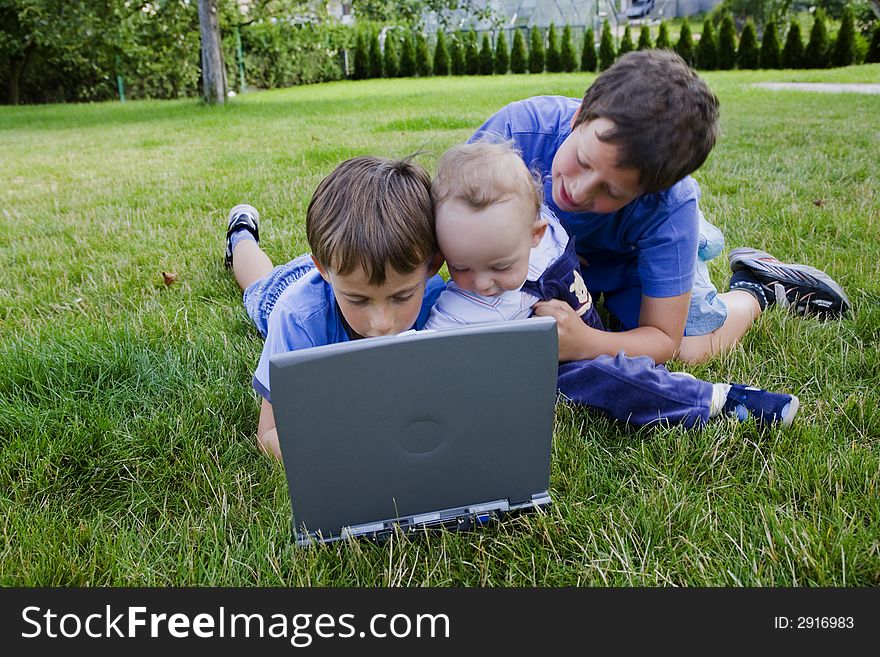 Three cute brothers study on computer