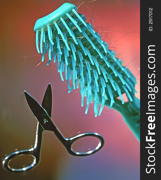Scissors and hairbrush on a grey background. Scissors and hairbrush on a grey background