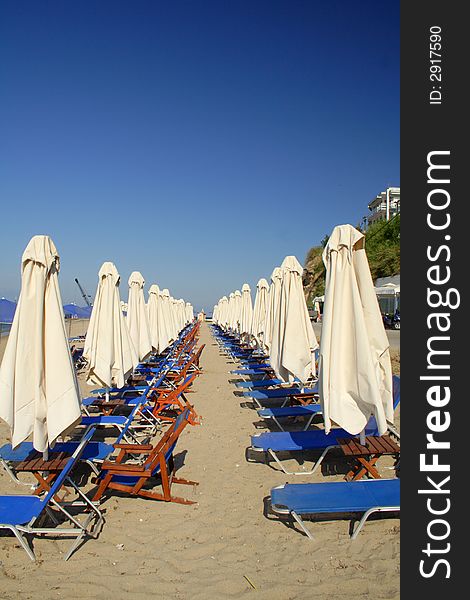 White beach umbrellas and blue seats