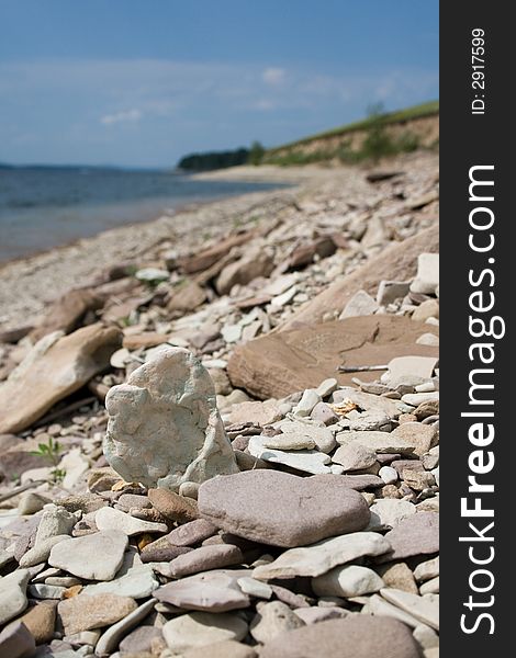 Shingly sea beach. Focus on single stone near camera.