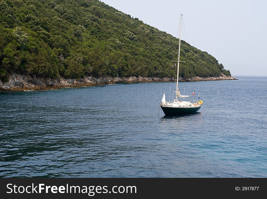 Lonely yacht near olive tree forest coast. Lonely yacht near olive tree forest coast