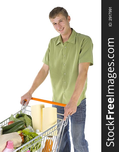 Young man standing with full of things trolley. Smiling and looking at camera. Young man standing with full of things trolley. Smiling and looking at camera
