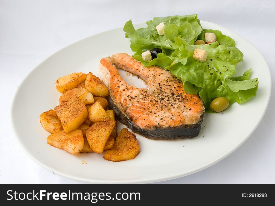Grilled Salmon with Lettuce Salad and fried Potatoes.
