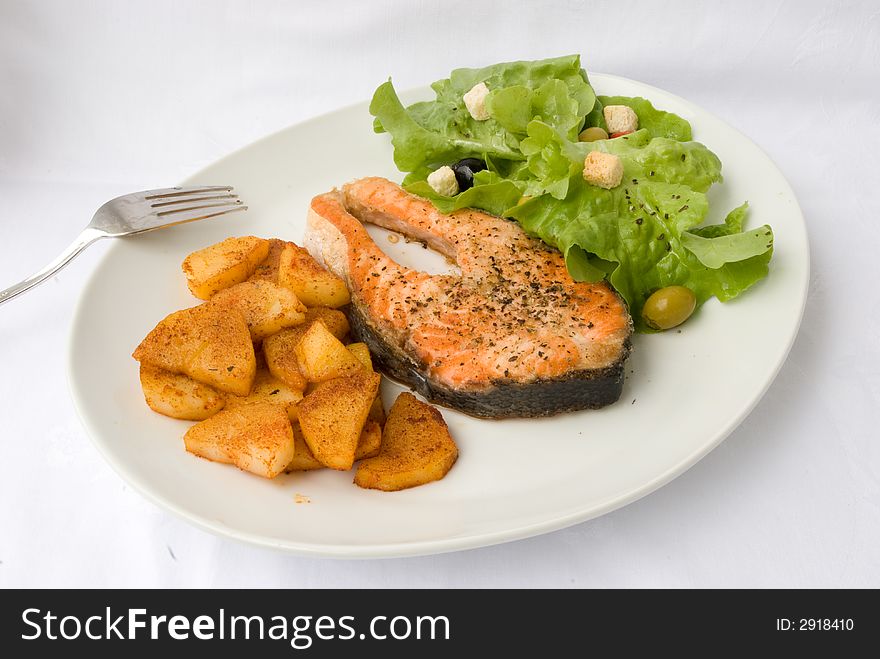 Grilled Salmon with Lettuce Salad and fried Potatoes. Grilled Salmon with Lettuce Salad and fried Potatoes.