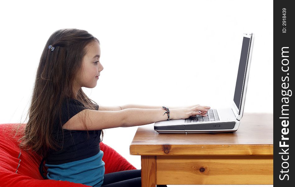 Young girl sitting down and working on a laptop. Young girl sitting down and working on a laptop