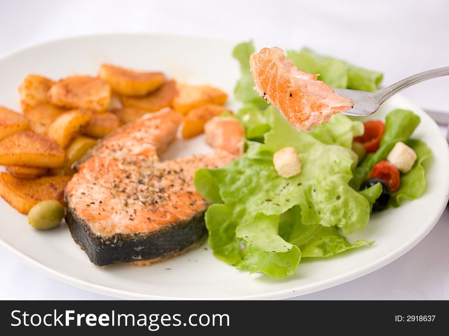 Grilled Salmon with Lettuce Salad and fried Potatoes. Grilled Salmon with Lettuce Salad and fried Potatoes.