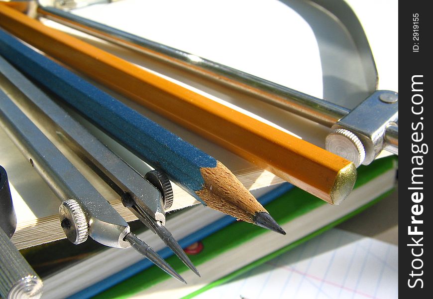 Pencils and compasses and pattern lay on a pile of books. Pencils and compasses and pattern lay on a pile of books.