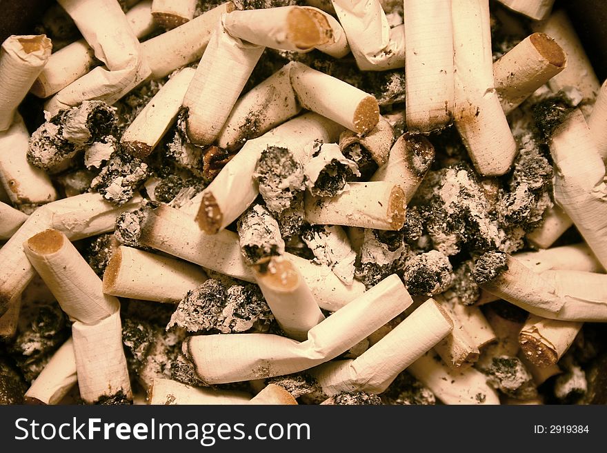 Background of a full ashtray with cigarette butts