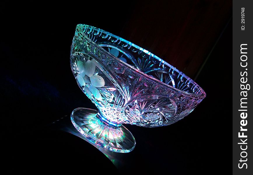 A glass bowl with hints of glowing blue, green, purple and red colours. A glass bowl with hints of glowing blue, green, purple and red colours.