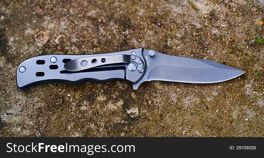 Folding knife lying on the pavement, waiting for its hour.