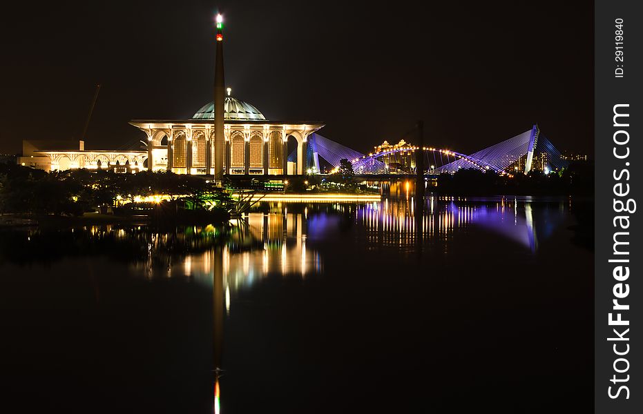Putrajaya view from putrajaya bridge at night with a reflection of water.