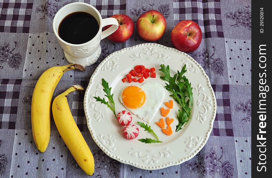 Heart shaped fried egg on beautiful plate. Healthy breakfast.
