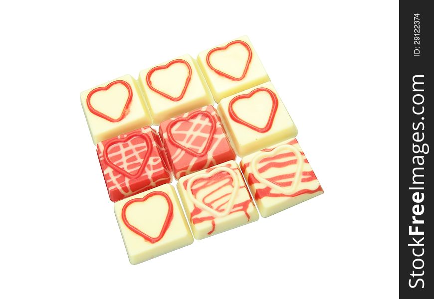 Red heart shape raised over pure white chocolate square. Red heart shape raised over pure white chocolate square