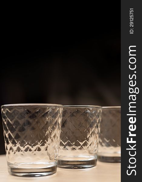 Transparent Glasses with Black Background on Wooden Table