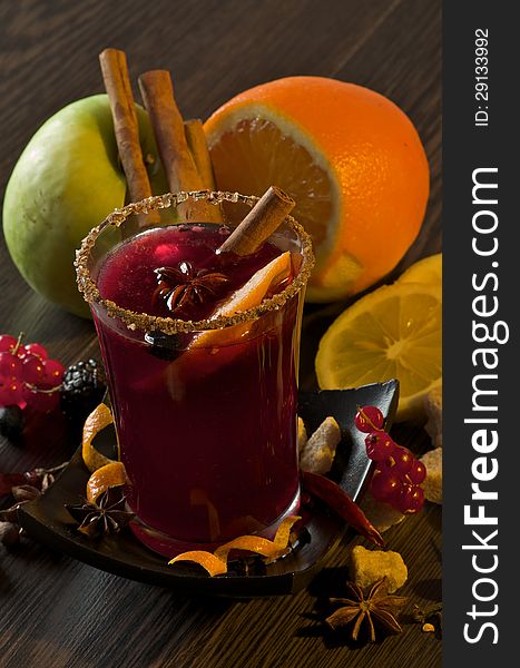 Arrangement of Fruits with Red Currant, Apple and Orange with Glass of Mulled Wine and Cinnamon Stick, Slice of Orange and Anise Star closeup on Dark Wood background. Arrangement of Fruits with Red Currant, Apple and Orange with Glass of Mulled Wine and Cinnamon Stick, Slice of Orange and Anise Star closeup on Dark Wood background