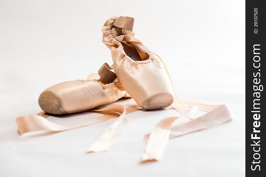 Pink ballet shoes over white background