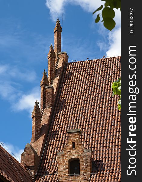 Roof tiles and decorations of a building in the middle replaced in Malbork. Poland. Roof tiles and decorations of a building in the middle replaced in Malbork. Poland