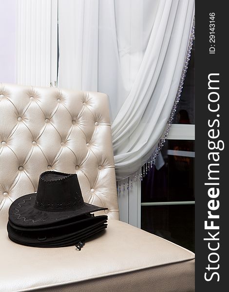 Stack of black-hat on luxurious couch in restaurant. Stack of black-hat on luxurious couch in restaurant