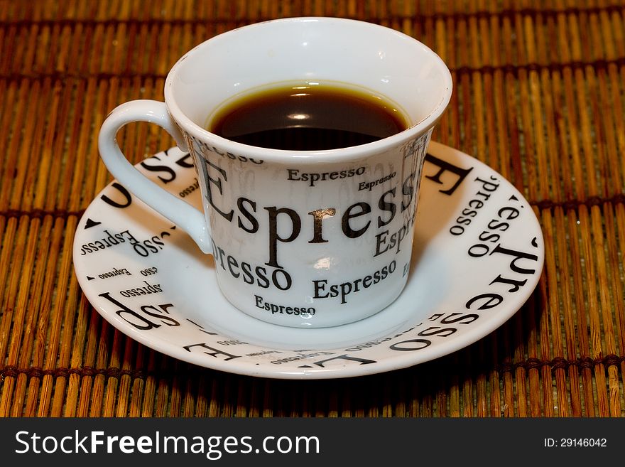 Black espresso in a cup against a bamboo background
