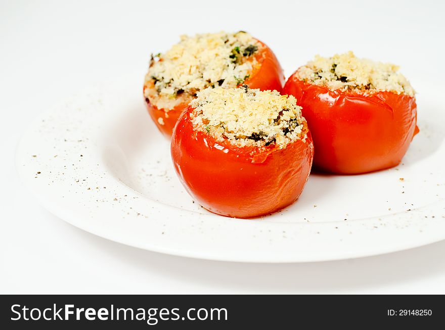 Three stuffed tomatoes on a white plate