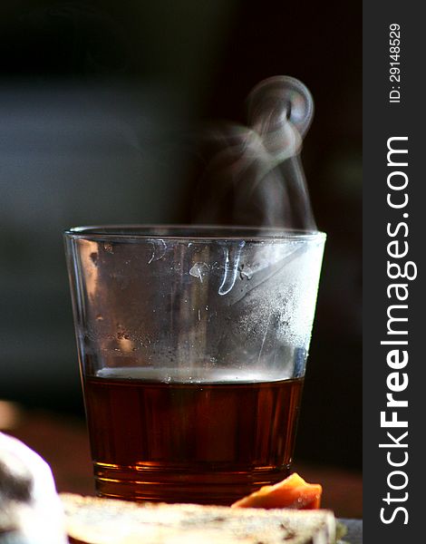 Steaming tea in a glass shot during the sunrise