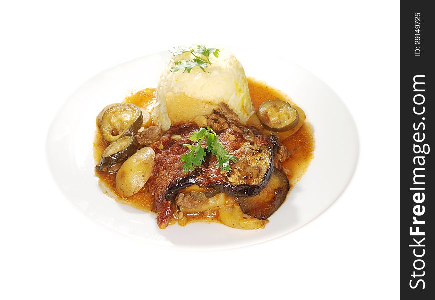 Eggplant dish, fried vegetables in juicy sauce, next to bowl of rice