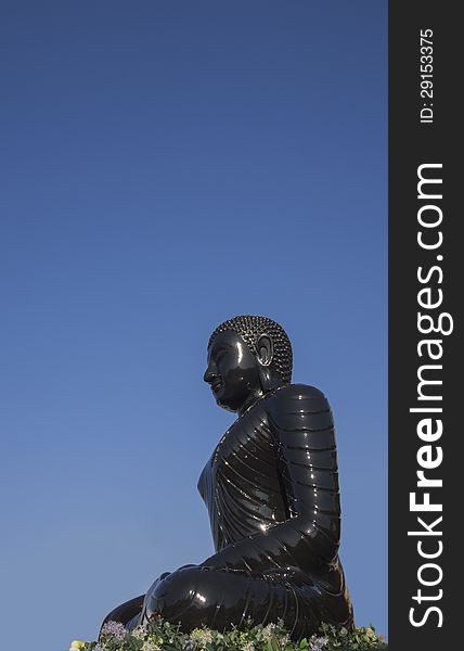 Buddha statue in blue sky background, black statue. Buddha statue in blue sky background, black statue