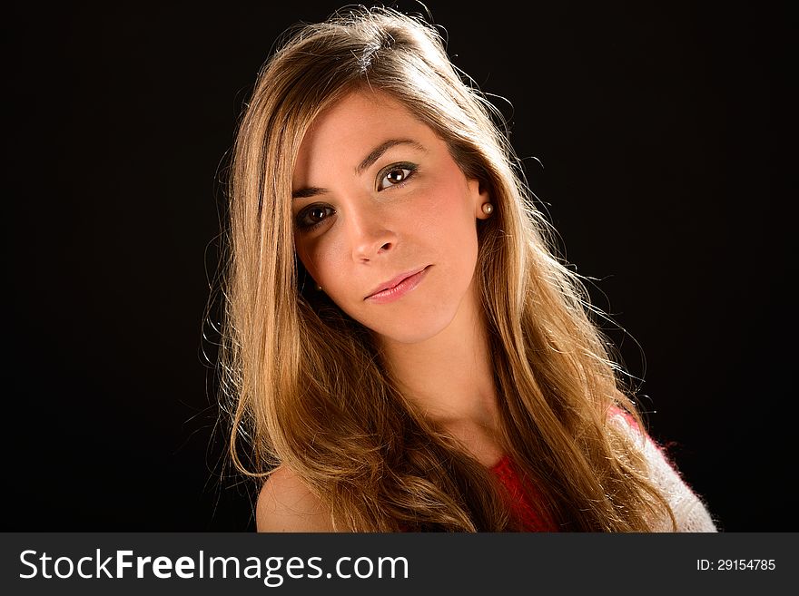 Portrait of a young blonde woman studio portrait on black background