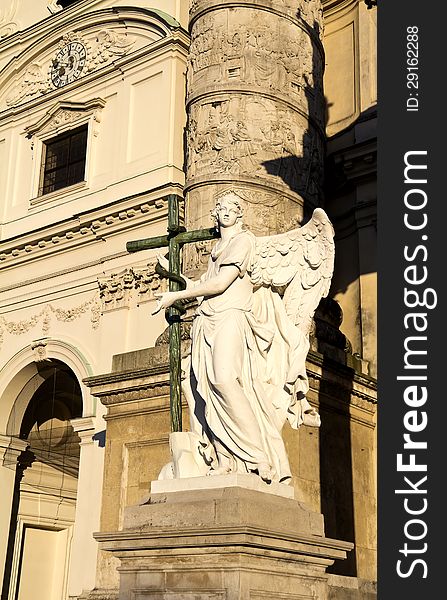 Angel statue with cross in front of Karlskirche (St. Charles's Church), Vienna, Austria