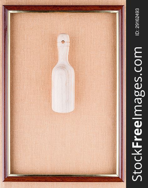 Wooden scoop in the frame on a linen background. Wooden scoop in the frame on a linen background