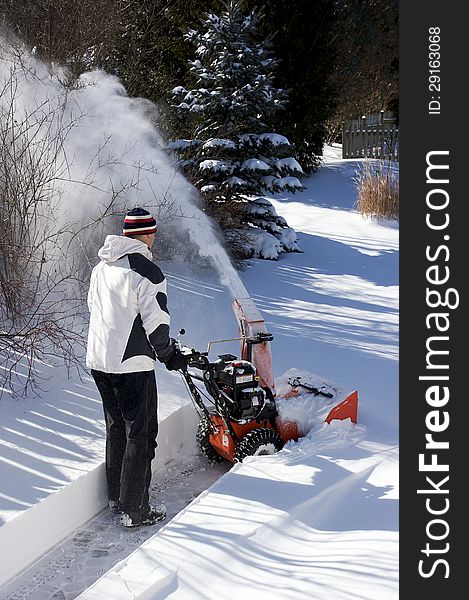 A man uses a snow blower to clear more than a foot of snow from a walkway in Ontario Canada after one of the biggest winter storms in years. A man uses a snow blower to clear more than a foot of snow from a walkway in Ontario Canada after one of the biggest winter storms in years.