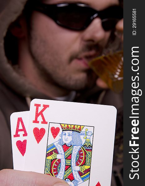 Poker player is drinking and showing his cards. Poker player is drinking and showing his cards.