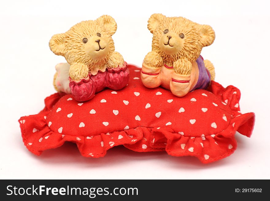 Sweet toy bears over soft heart shaped pillow. Sweet toy bears over soft heart shaped pillow