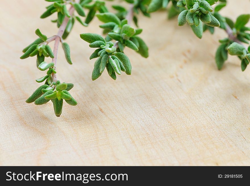 Green fresh thyme on a wooden plate