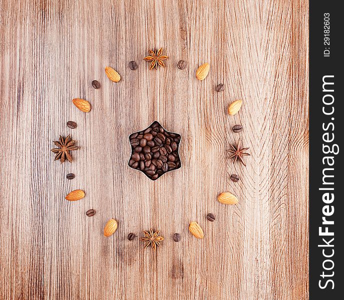 Clock face on a wooden background of almonds and coffee beans. Clock face on a wooden background of almonds and coffee beans