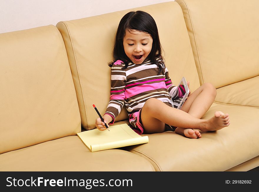 Asian girl child writing on the living room. Asian girl child writing on the living room
