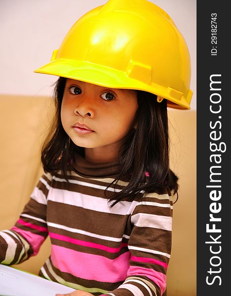 Beautiful asian girl acting as an engineer wearing yellow helmet. Beautiful asian girl acting as an engineer wearing yellow helmet