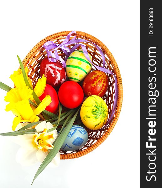 Colorful painted Easter eggs with flowers and ribbon in wooden basket. Colorful painted Easter eggs with flowers and ribbon in wooden basket