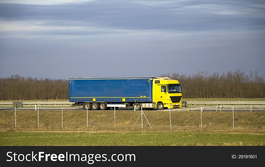 Yellow blue truck on highway