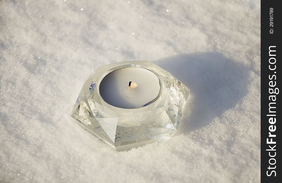 White candle on the snow