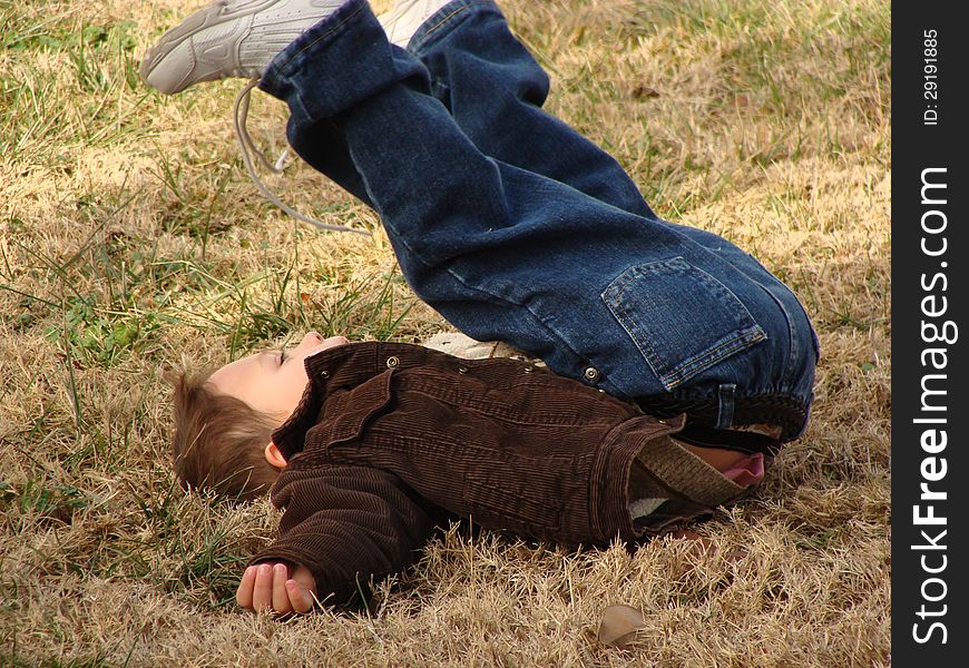 Happy little boy playing and rolling on the grass. Happy little boy playing and rolling on the grass