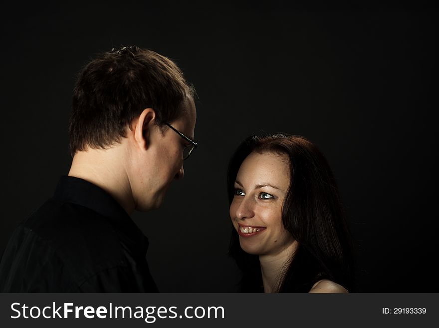 Portrait of young couple in studio on black background