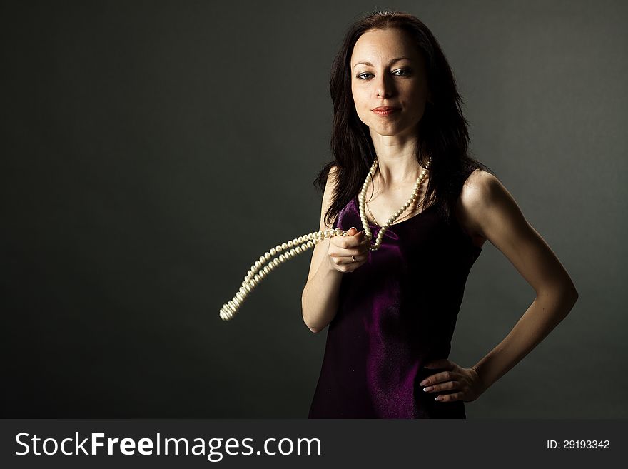 Portrait of lovely woman in vinous dress with bead