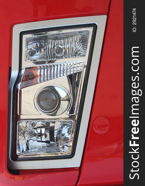 Head-light of red truck with halogen bulbs. Head-light of red truck with halogen bulbs.