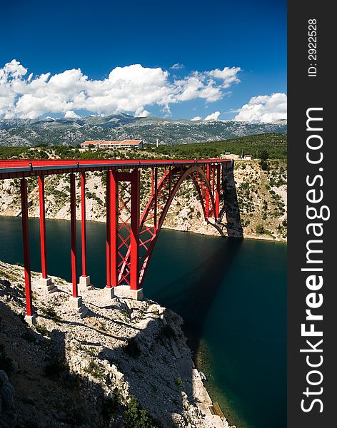 Steel red bridge in Maslenica, Croatia, with blue sky and clouds