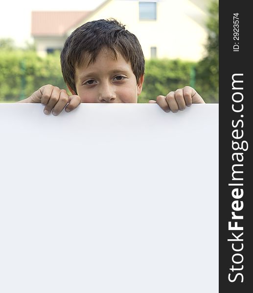 Boy keeps sheet of paper in courtyard of the building